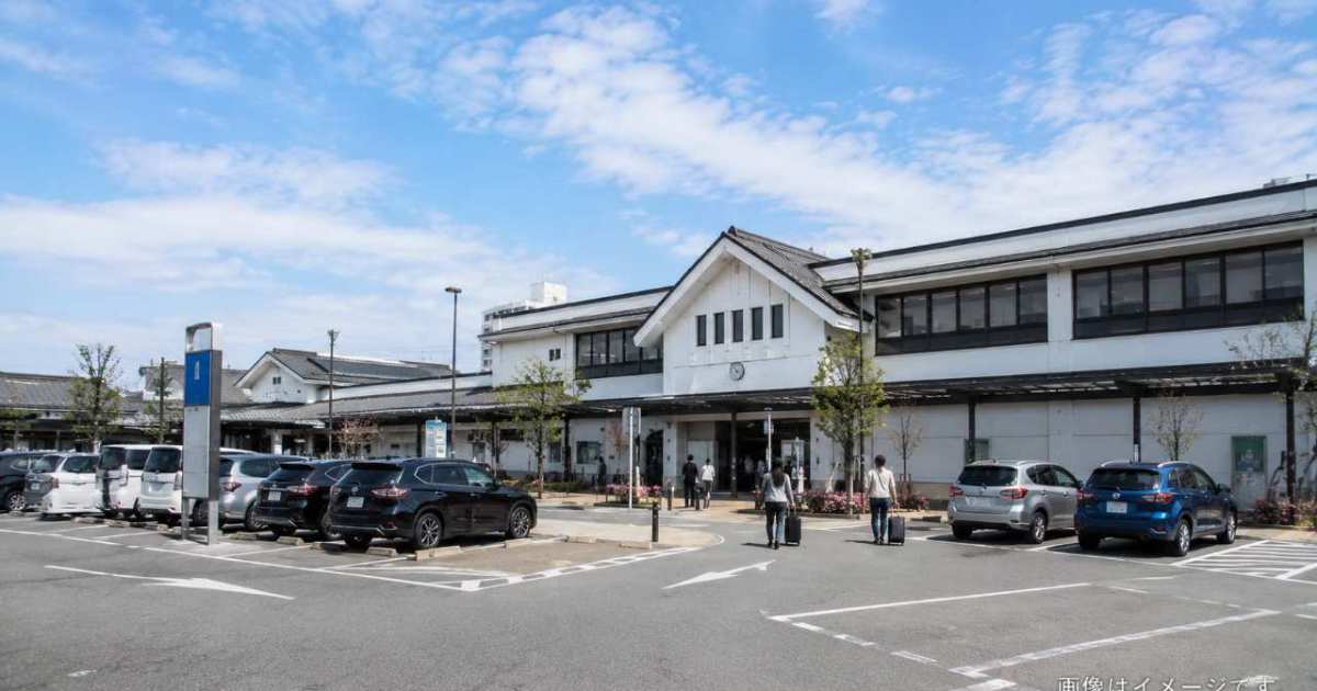 出雲大社の参道入口を背景に旅行用スーツケースとコインロッカーを手前へ配置した構図